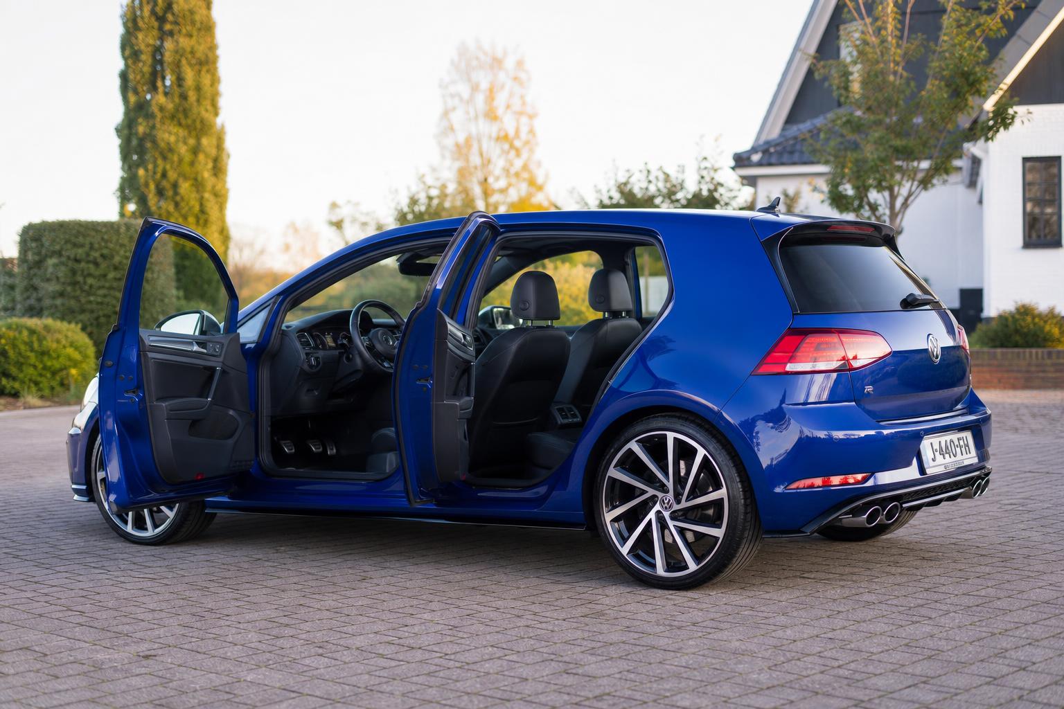 Freshly detailed Lapiz Blue Volkswagen Golf R shown from the side with doors open, revealing spotless interior and mirror-finish exterior